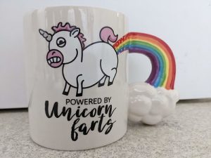 A mug featuring a unicorn farting a rainbow