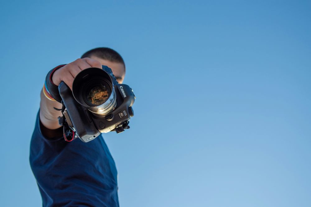 A man holding a camera to hide his face